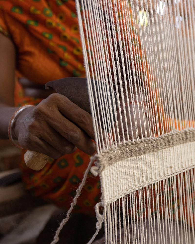 A woman weaving bright-colored fabric